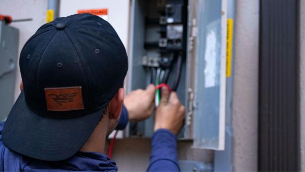 An electrician working inside an electrical panel